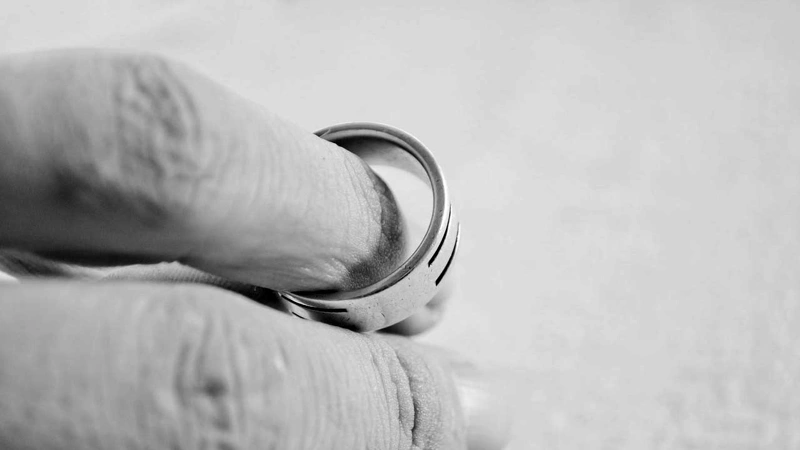 En persons hand som håller en vigselring.