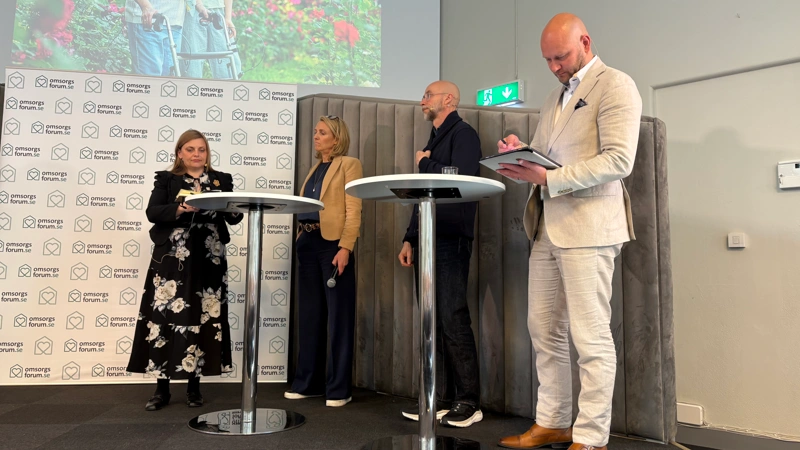 En grupp människor som står runt ett bord för ett panelsamtal.